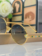 Bvlgari round sunglasses close-up with dark lenses and gold-tone frame, multicolor jewel detail
