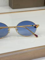 Bvlgari round sunglasses side view with blue lenses and gold-tone metal frame, jewel accents