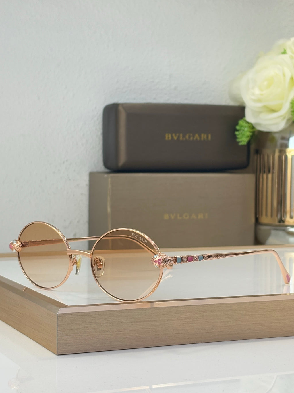 Bvlgari round sunglasses with light brown lenses and gold-tone metal frame, jeweled accents
