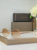 Bvlgari round sunglasses with light brown lenses and gold-tone metal frame, jeweled accents