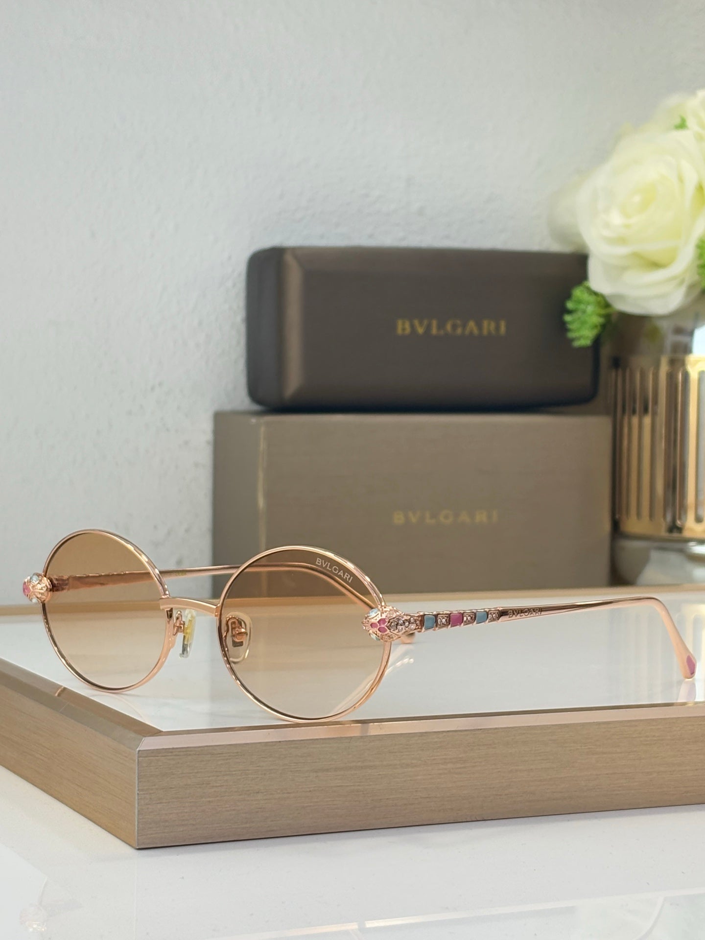 Bvlgari round sunglasses with light brown lenses and gold-tone metal frame, jeweled accents