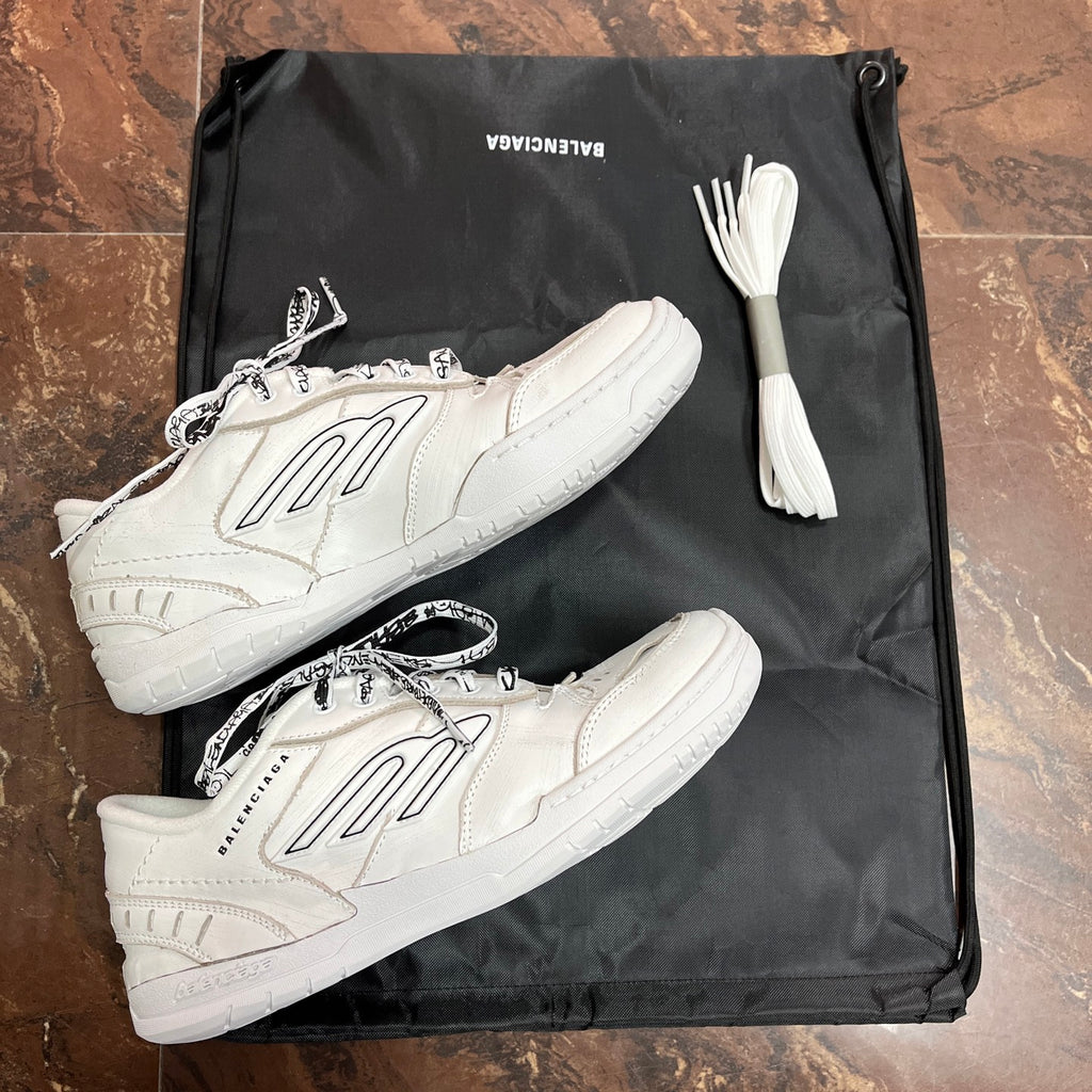 White lace-up low-top sneakers with black logo on side