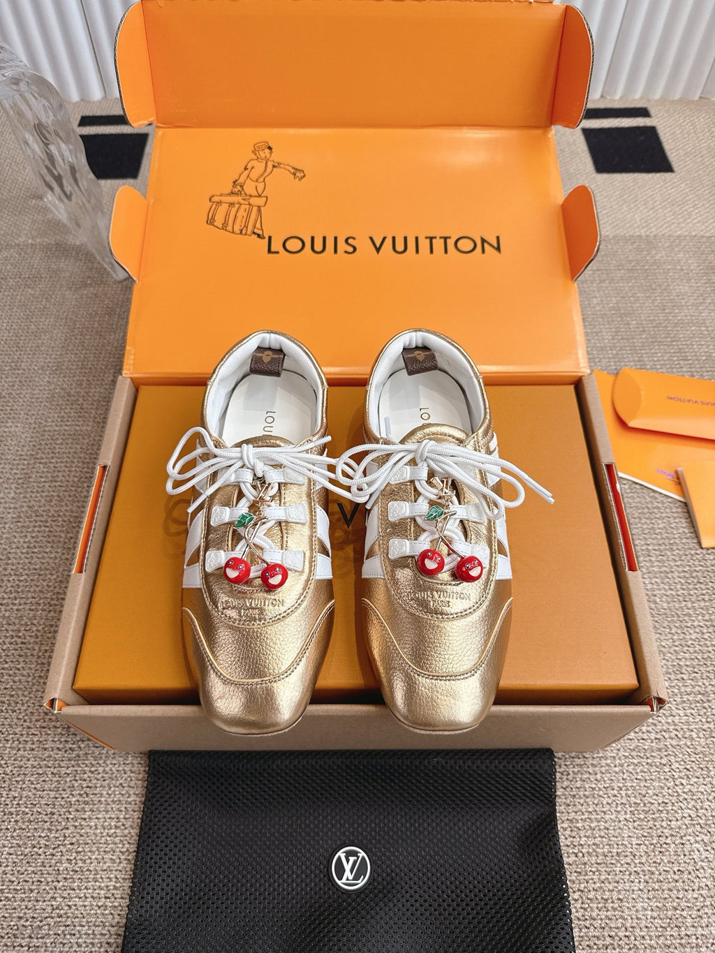 Louis Vuitton metallic gold sneakers with white laces and cherry charm on side