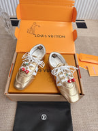 Louis Vuitton metallic gold sneakers with white panels, laces, and cherry charm