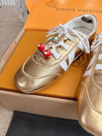 Louis Vuitton metallic gold sneakers with white laces and gold leather upper closeup