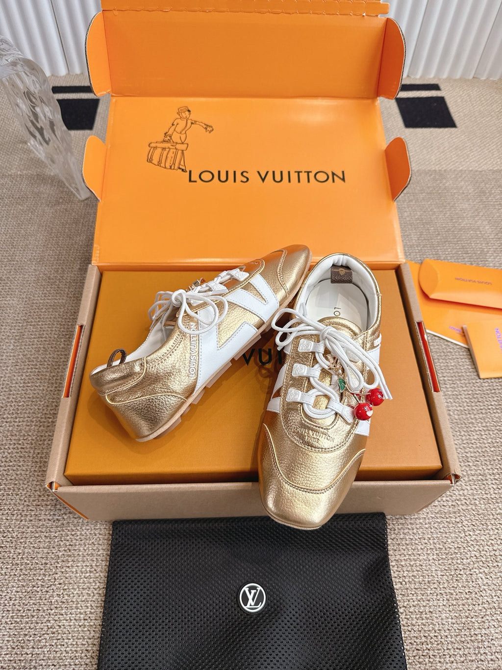 Louis Vuitton metallic gold sneakers with white laces, side panels, and cherry charm
