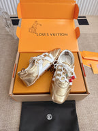 Louis Vuitton metallic gold sneakers with white laces, side panels, and cherry charm