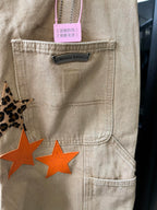 Light khaki pants front pocket with brand label and orange star patch design