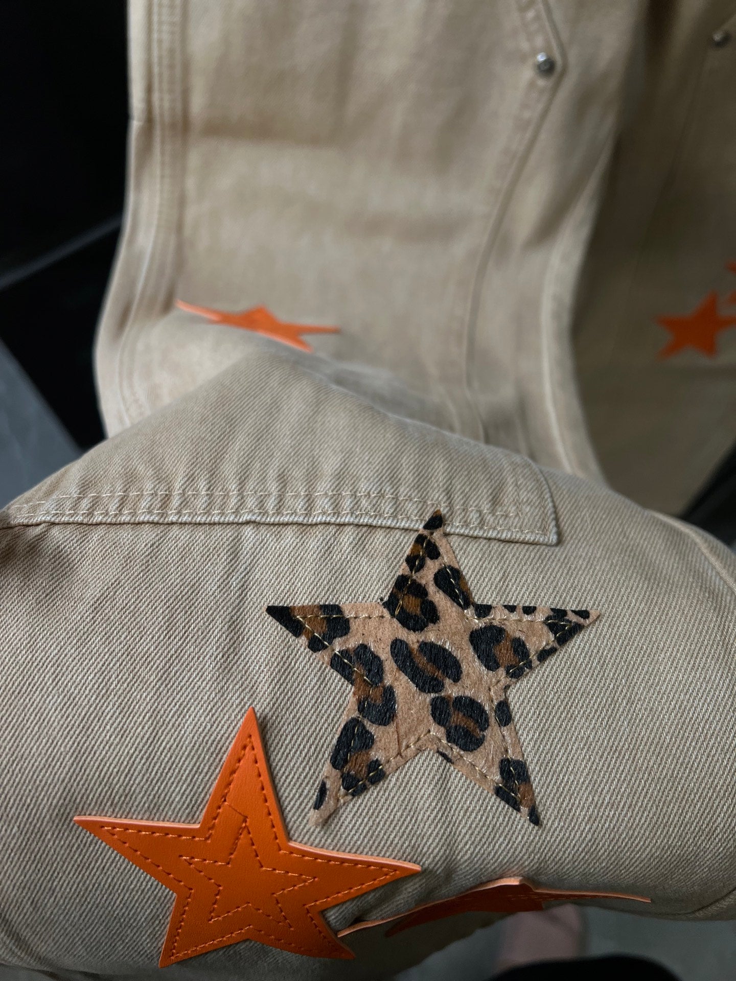 Denim pants detail with orange star graphic and leopard-print star patch