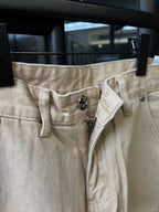 Light khaki waistband and button detail with belt loops and denim texture