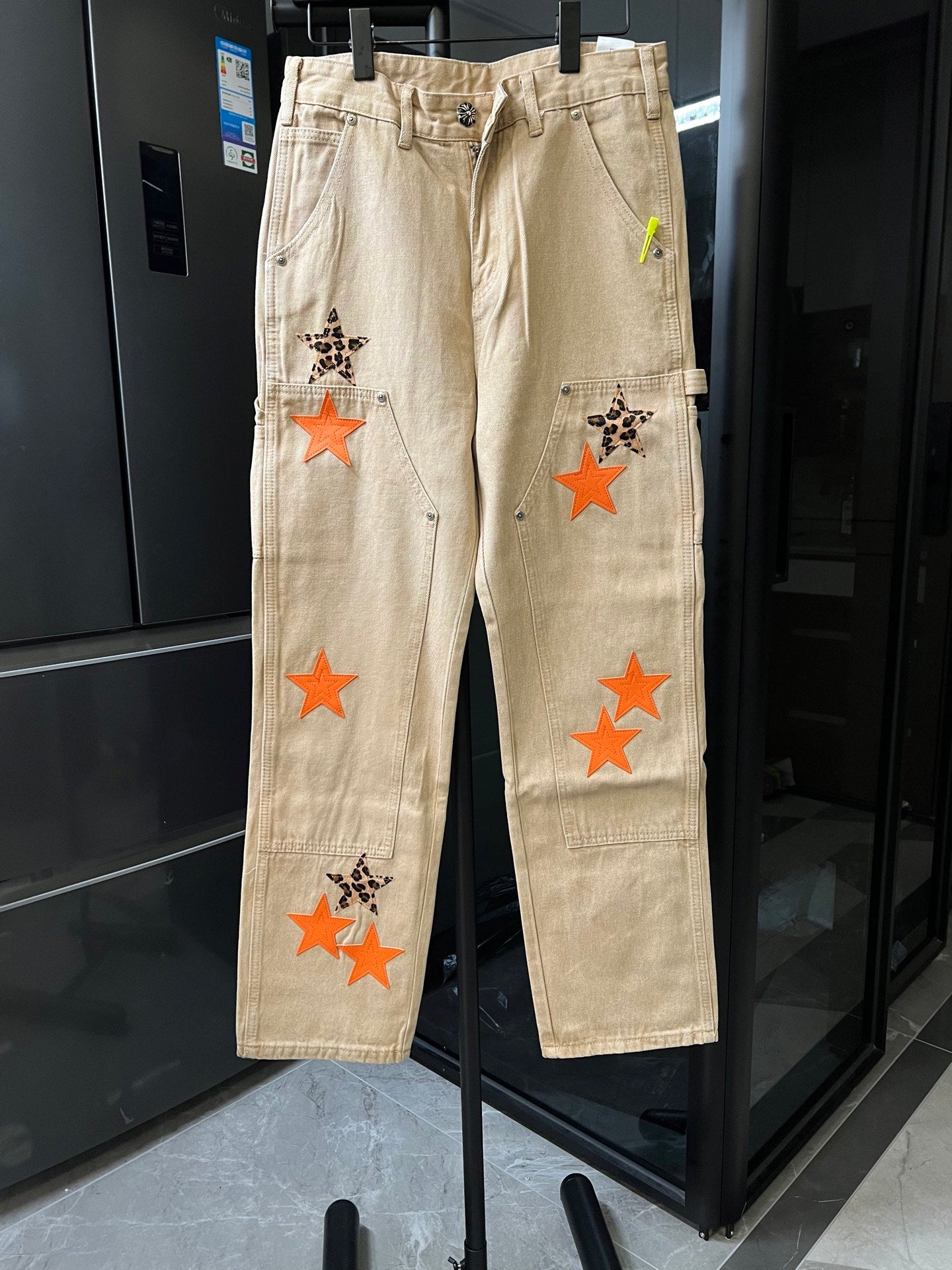 Light khaki pants with orange star patches and leopard-style star applique