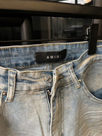 Light-wash denim jeans with waistband button closure and AMIRI logo label