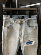 Light-wash denim jeans with back pockets and a distressed knee patch
