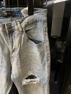 Amiri light-wash jeans with distressed knee tear and frayed fabric