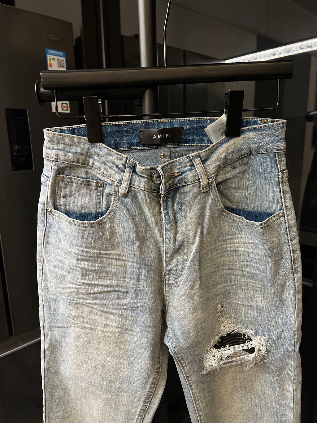 Amiri light-wash jeans with belt loops, button fly, and ripped thigh detail