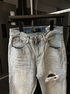 Amiri light-wash jeans with belt loops, button fly, and ripped thigh detail