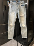 Light wash jeans with ripped knees and distressed patches on the thighs and calves