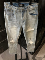 Light wash jeans with distressed knee rips, whiskering, and a frayed hem