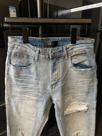 Light wash denim jeans with embroidered stitching, belt loops, and ripped thigh panels