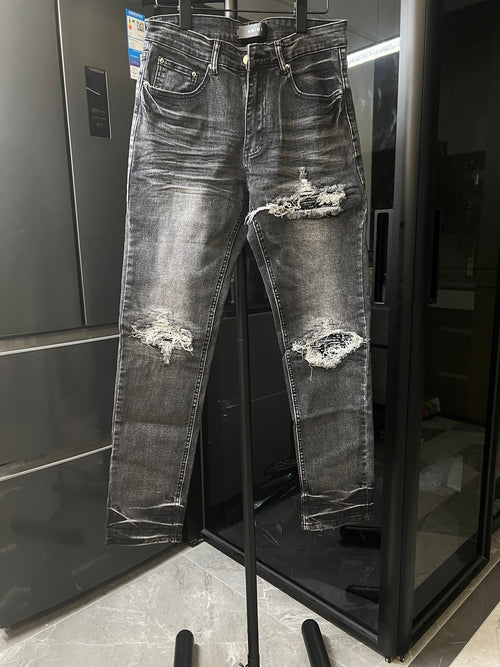 Distressed gray denim jeans with ripped knees and frayed hem details