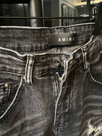 Amiri gray denim jeans with logo waistband patch and visible button fly