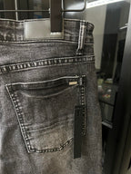 Gray denim jeans with front belt loops and AMIRI label on waistband