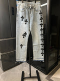 Light wash denim pants with black cross patches, button fly, straight leg