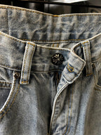 Denim waistband with button fly and metal button detail on light wash pants