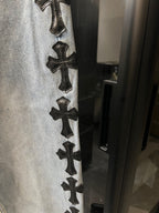 Denim pants with vertical row of black cross patches along side seam