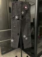 Dark gray denim cargo-style pants with star appliques and buttoned front pockets