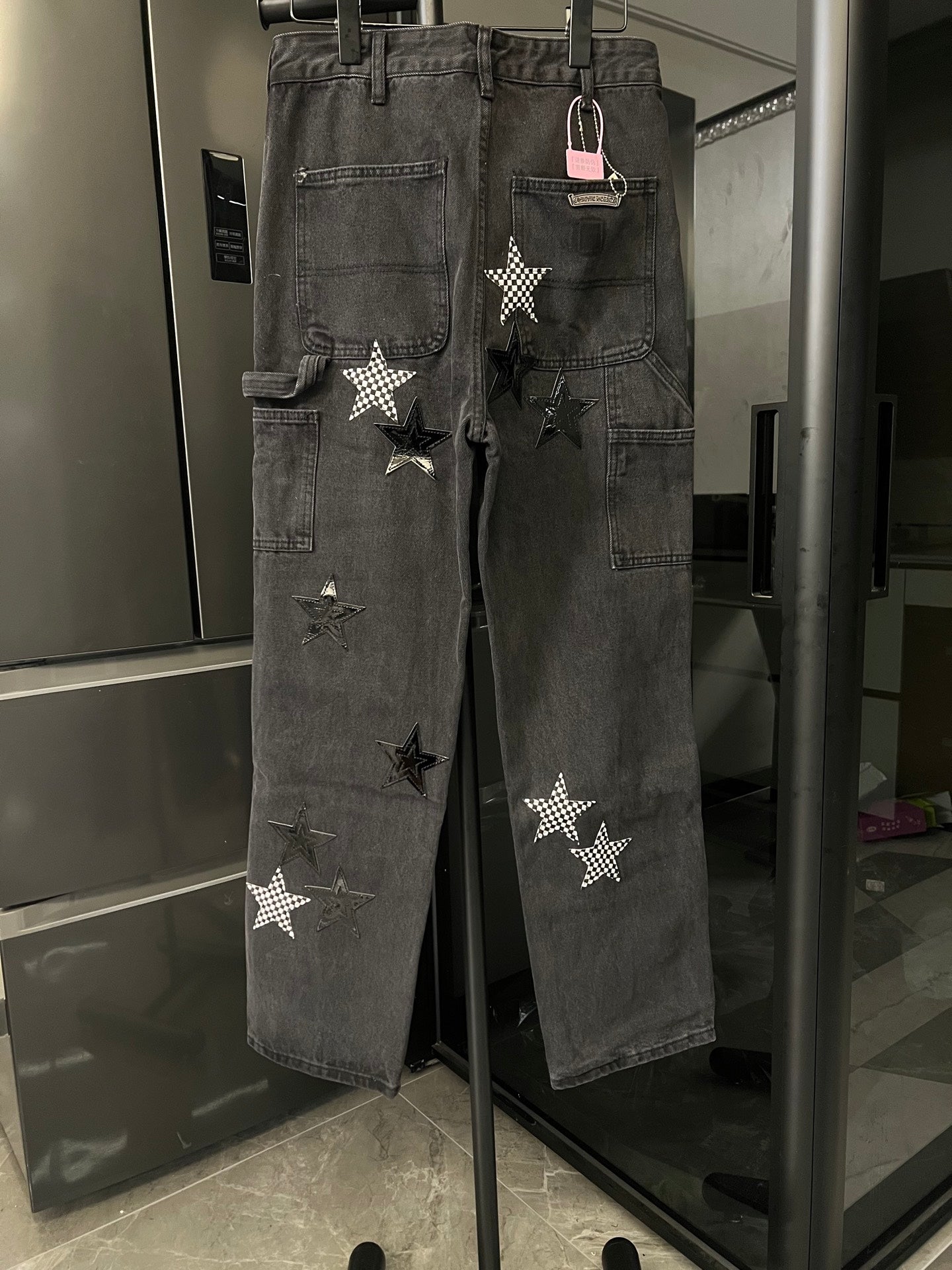 Dark gray denim cargo-style pants with star appliques and buttoned front pockets