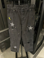 Dark gray denim pants with double-stitched waistband and star patches on front