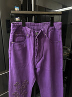 Purple pants with front pockets and belt loops, embroidered cross details on leg