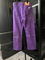 Purple pants with back pockets and embroidered cross patches, straight leg