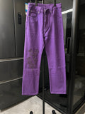 Purple pants with embroidered cross patches on the thigh, button fly, belt loops