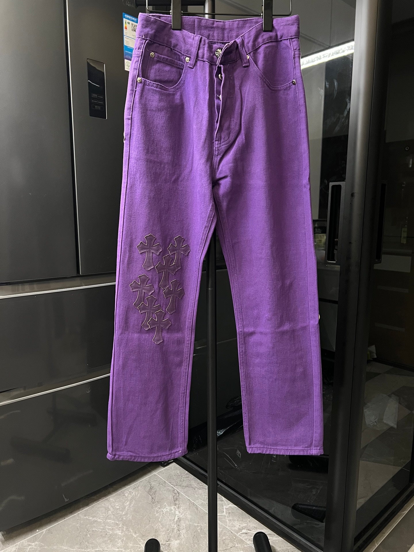 Purple pants with embroidered cross patches on the thigh, button fly, belt loops