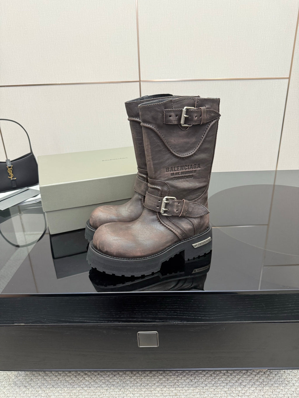 Balenciaga women’s mid-calf leather boots with buckle strap and textured lug outsole