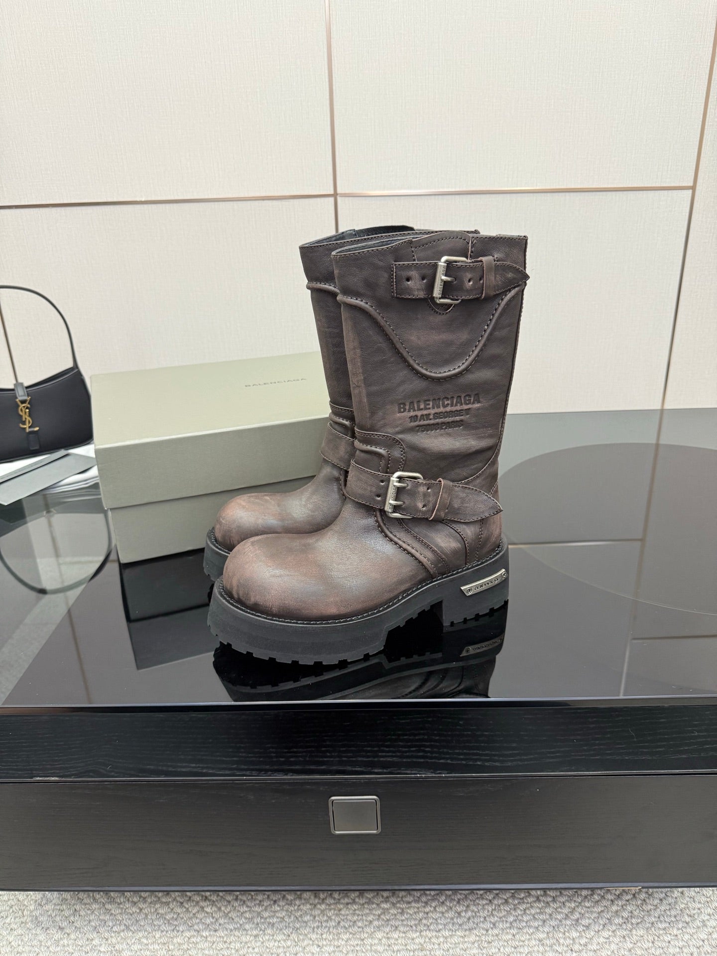 Balenciaga women’s mid-calf leather boots with buckle strap and textured lug outsole