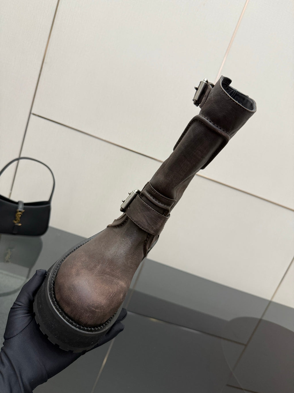 Balenciaga women’s mid-calf leather boots shown from side with buckle strap and lug sole
