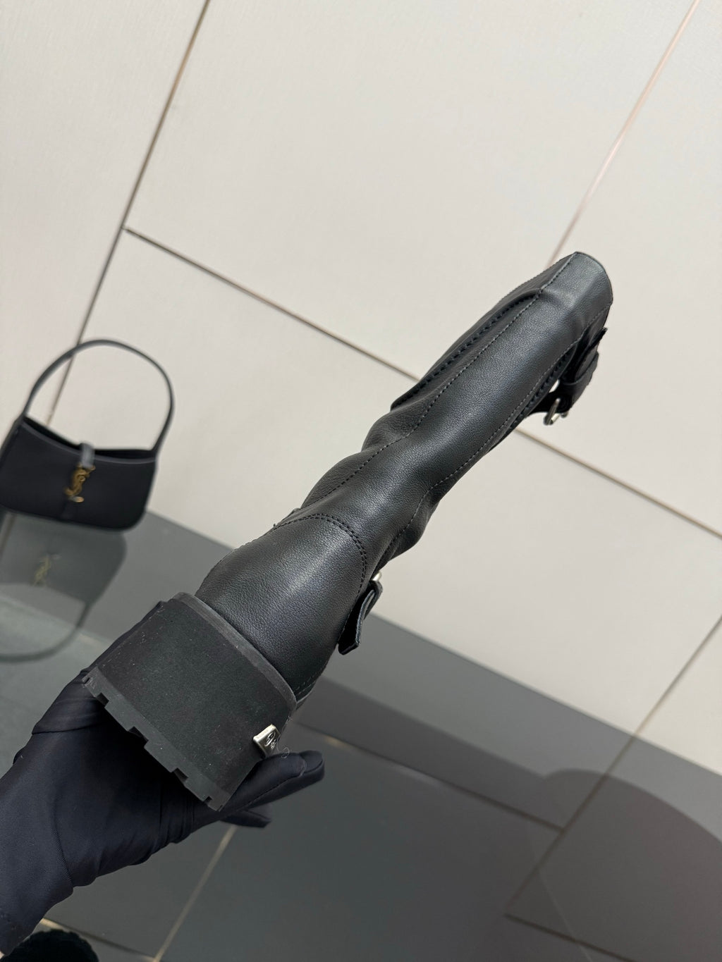 Black leather tall boots with adjustable strap and lug sole