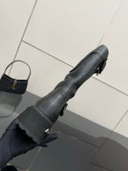 Black leather tall boots with adjustable strap and lug sole
