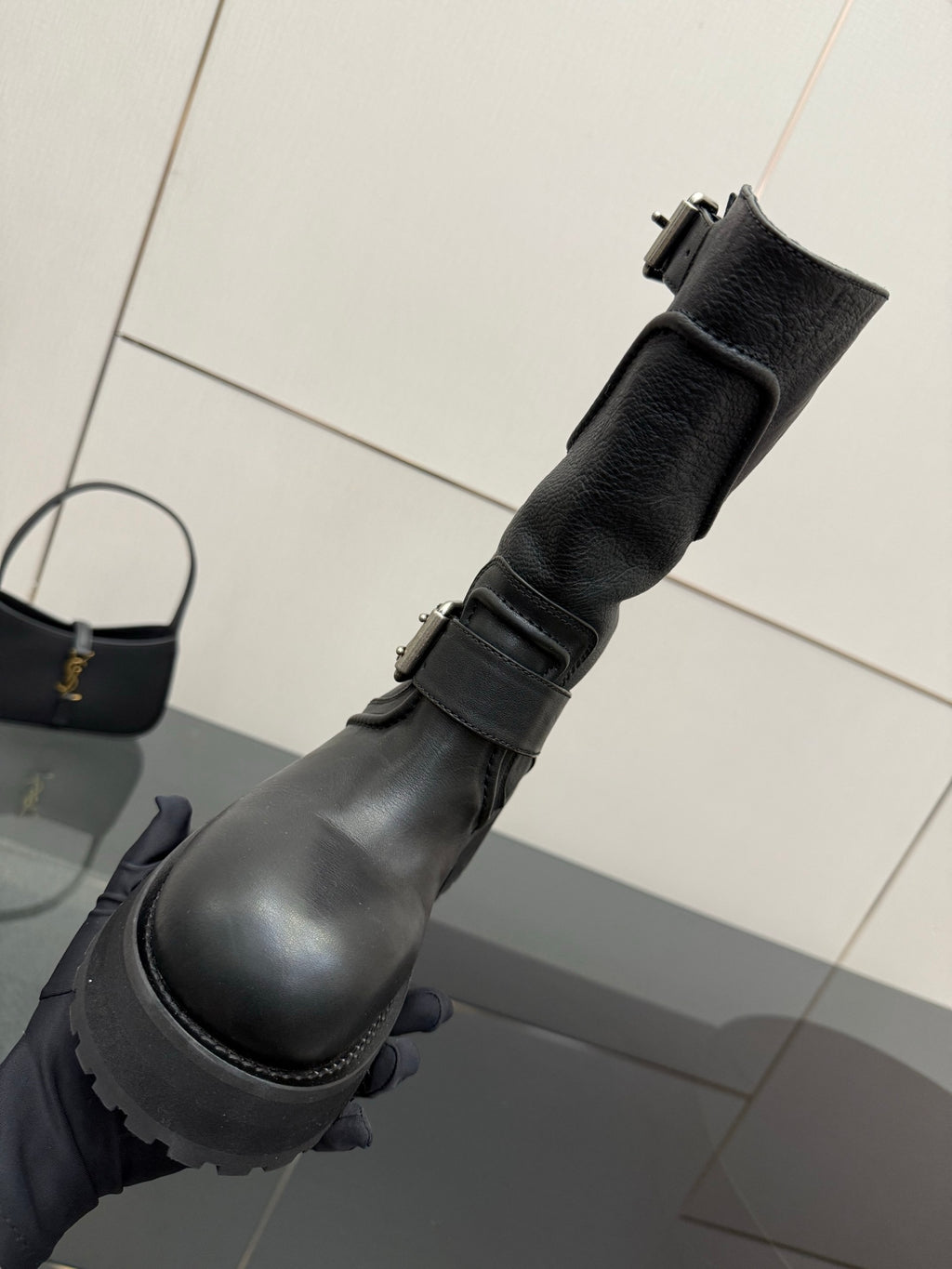 Black leather ankle-high boots with buckle straps and lug sole