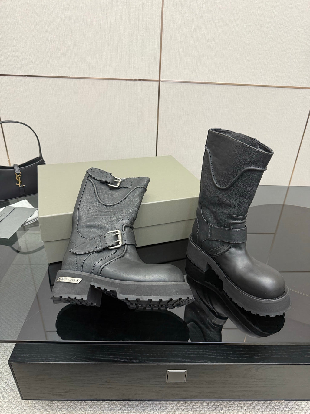 Gray and black leather boots with buckled straps and thick lug sole