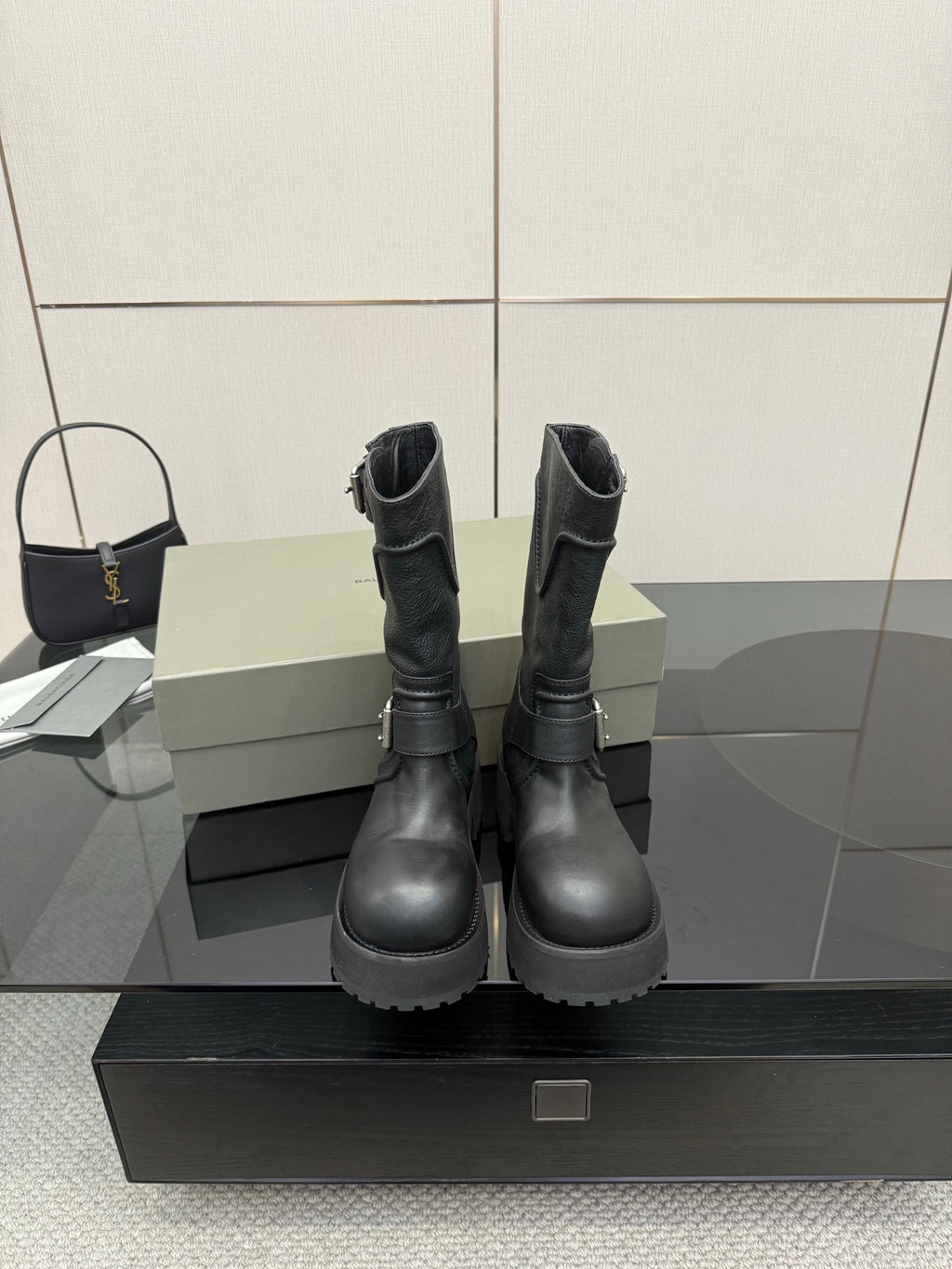 Black leather moto boots with lace-up and side buckles