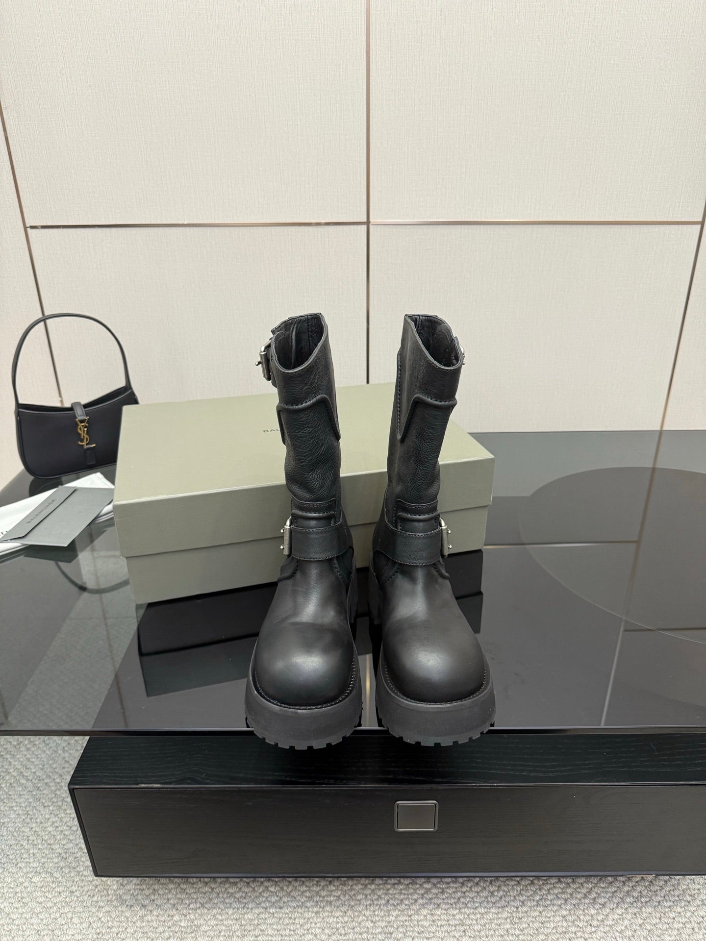 Black leather moto boots with lace-up and side buckles