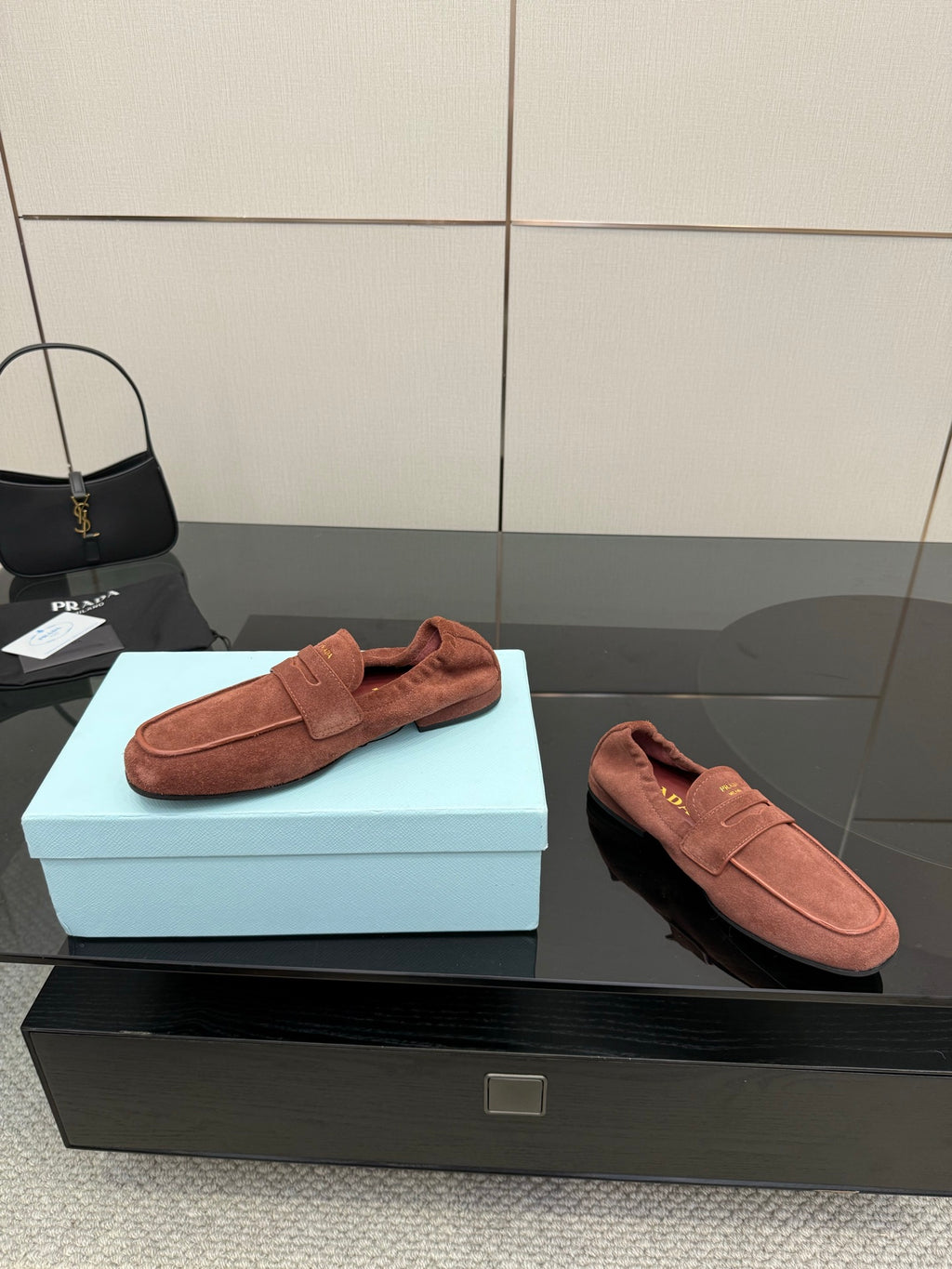 Prada rust-brown suede loafers, one side view and one outsole view