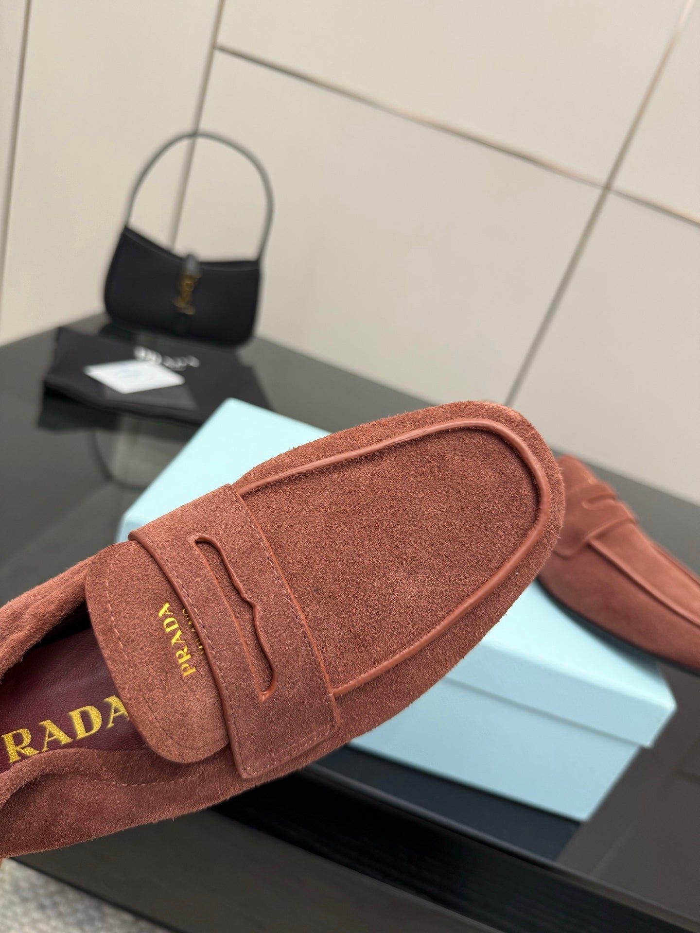 Prada rust-brown suede loafer close-up of strap and stitched edge