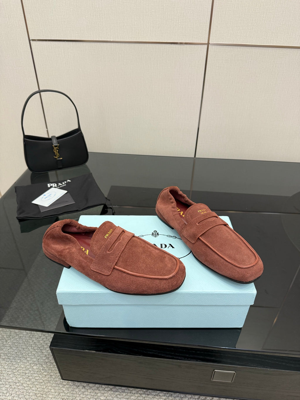 Prada rust-brown suede loafers, left and right shoes on display