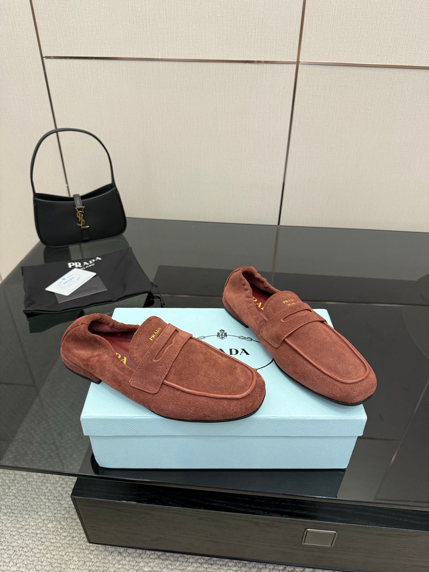Prada rust-brown suede loafers, left and right shoes on display