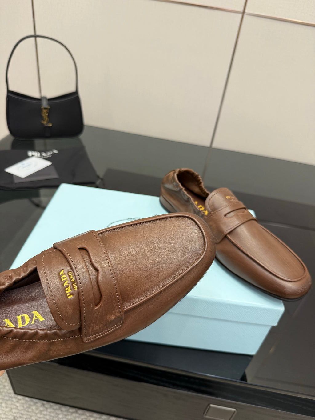 Tan leather loafer upper with stitched seam and Prada lettering on strap panel